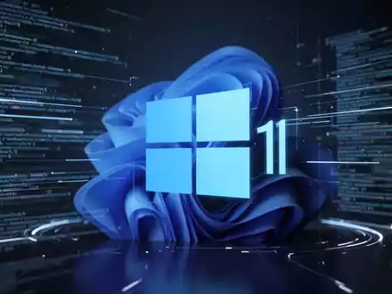 Stilisiertes, leuchtend blaues Windows 11-Logo in futuristischer digitaler Oberfläche mit verschwommenen Codezeilen und Datenfluss. - Foto: über boerse-global.de