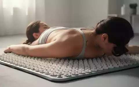 Eine Person liegt mit dem Rücken auf einer modernen Akupressurmatte mit vielen kleinen Spitzen, um Entspannung zu finden. - Foto: über boerse-global.de