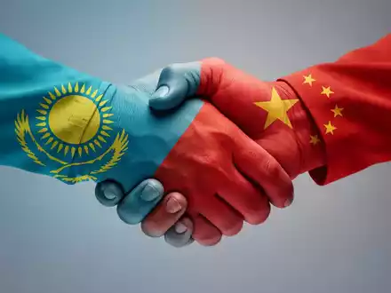 Eine stilisierte Grafik eines Händedrucks, gebildet aus den Flaggen Kasachstans und Chinas, die ein Handelsvolumen von 100 Milliarden symbolisiert. - Foto: über boerse-global.de