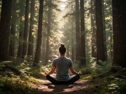 Eine Person meditiert ruhig in einem sonnenbeschienenen Wald, umgeben von Bäumen und sanftem Licht, was Resilienz und Naturverbindung symbolisiert. - Foto: über boerse-global.de