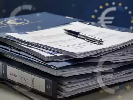 Ein Stapel offizieller Dokumente oder Aktenordner, einige geöffnet, mit einem Stift darauf, symbolisiert die Vereinfachung von EZB-Regeln. - Foto: über boerse-global.de
