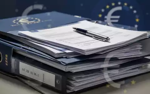Ein Stapel offizieller Dokumente oder Aktenordner, einige geöffnet, mit einem Stift darauf, symbolisiert die Vereinfachung von EZB-Regeln. - Foto: über boerse-global.de