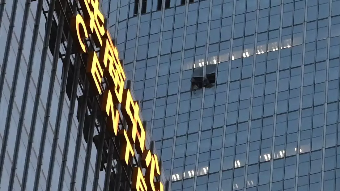 Das Loch an der Fassade des China Zun befand sich in den oberen Etagen.   - Bild: Johannes Neudecker/dpa