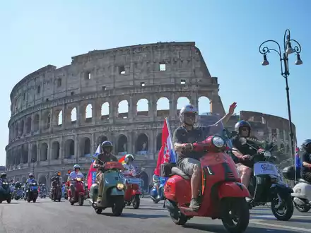 Vespa-Fans fahren am Kolosseum vorbei. - Foto: Alessandra Tarantino/AP/dpa