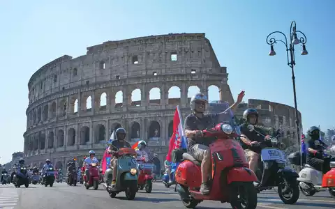 Vespa-Fans fahren am Kolosseum vorbei. - Foto: Alessandra Tarantino/AP/dpa
