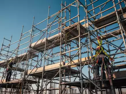 Ein komplexes Gerüst mit Sicherheitsausrüstung, das Stabilität und Präzision in der Bauindustrie symbolisiert. - Foto: über boerse-global.de