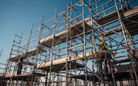 Ein komplexes Gerüst mit Sicherheitsausrüstung, das Stabilität und Präzision in der Bauindustrie symbolisiert. - Foto: über boerse-global.de