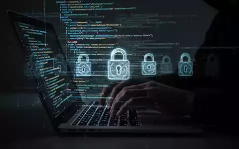 Schattenhafte Hände tippen auf Laptop mit leuchtendem Code und digitalen Schlössern, Symbol für Cyberbedrohungen und Prävention. - Foto: über boerse-global.de
