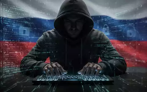 Verschattete Gestalt in Kapuzenjacke tippt auf leuchtender Tastatur, umgeben von digitalem Code, symbolisiert russische Cyber-Spionage. - Foto: über boerse-global.de