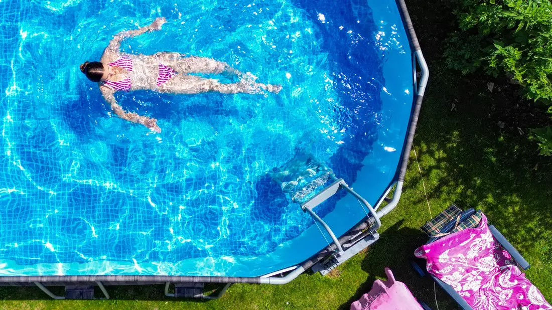 Ein Mädchen schwimmt in einem Pool in einem Garten von Brandenburg. - Bild: Patrick Pleul/dpa