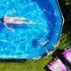 Ein Mädchen schwimmt in einem Pool in einem Garten von Brandenburg. - Bild: Patrick Pleul/dpa