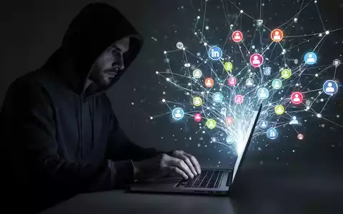 Eine schattenhafte Gestalt in Kapuzenpulli tippt auf Laptop, umgeben von leuchtendem digitalem Netzwerk und Social-Media-Symbolen. - Foto: über boerse-global.de