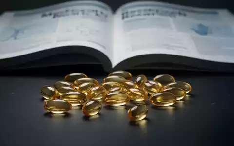 Omega-3-Fischölkapseln liegen auf einer dunklen Oberfläche, im Hintergrund eine unscharfe medizinische Forschungszeitschrift. - Foto: über boerse-global.de