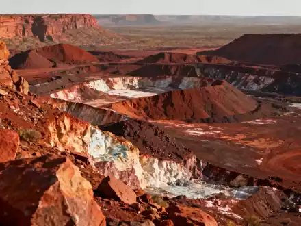 Eine stilisierte Darstellung der Logos von St George Mining und Hancock Prospecting, eingebettet in eine Bergbaulandschaft. - Foto: über boerse-global.de