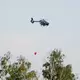 Ein Löschhubschrauber ist im Einsatz.  - Bild: Sebastian Willnow/dpa