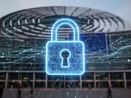 Ein stilisiertes, leuchtend blaues Vorhängeschloss-Symbol mit digitalen Datenströmen vor einem unscharfen Hintergrund des Europäischen Parlaments. - Foto: über boerse-global.de
