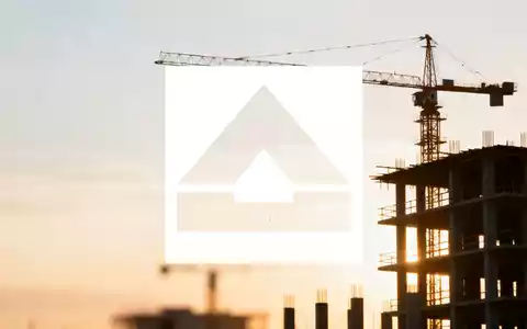 Abstrakte Baustelle bei Sonnenaufgang, mit Kranen und Gebäudestrukturen, die Wachstum und Stabilität im Bausektor andeuten. - Foto: über boerse-global.de
