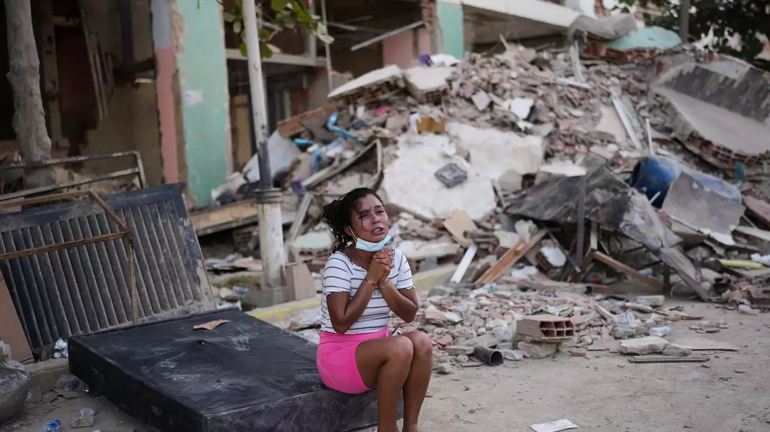Eine Frau weint neben beschädigten Gebäuden in La Guaira. - Bild: Matias Delacroix/AP/dpa