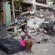 Eine Frau weint neben beschädigten Gebäuden in La Guaira. - Bild: Matias Delacroix/AP/dpa