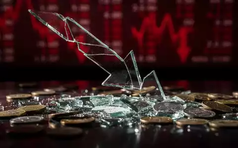 Ein zerbrochener, nach unten zeigender Pfeil aus Glas, umgeben von verstreuten, entwerteten Münzen, symbolisiert einen Aktienabsturz. - Foto: über boerse-global.de