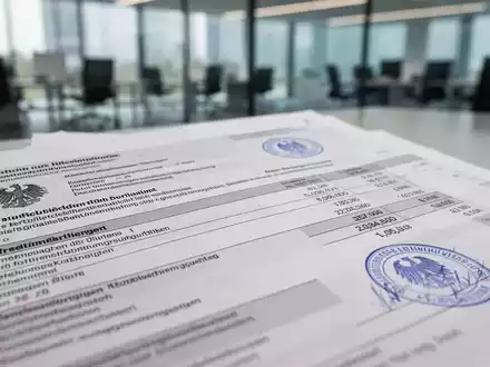 Nahaufnahme von offiziellen Finanzdokumenten mit deutschem Text und Stempeln, die neue Steuerregelungen und Compliance symbolisieren. - Foto: über boerse-global.de