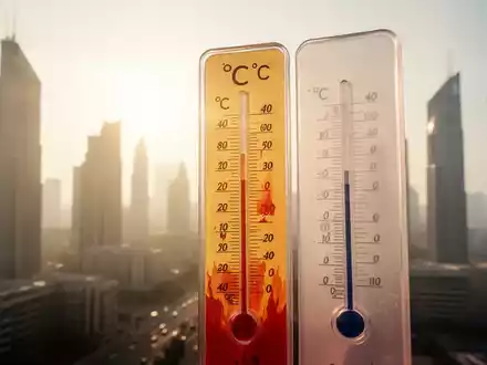 Ein Thermometer zeigt extreme Hitze, über 40 Grad Celsius, vor einer verschwommenen Stadtkulisse während einer Hitzewelle. - Foto: über boerse-global.de