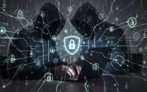 Verschattete Gestalt in Kapuzenjacke tippt auf Laptop, umgeben von leuchtenden digitalen Linien und abstrakten Netzwerksymbolen, die Cyberbedrohungen darstellen. - Foto: über boerse-global.de