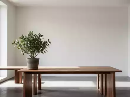 Ein minimalistisches Interieur mit klaren Linien, natürlichem Licht und einer einzelnen Pflanze auf einem Holztisch, das Ruhe ausstrahlt. - Foto: über boerse-global.de