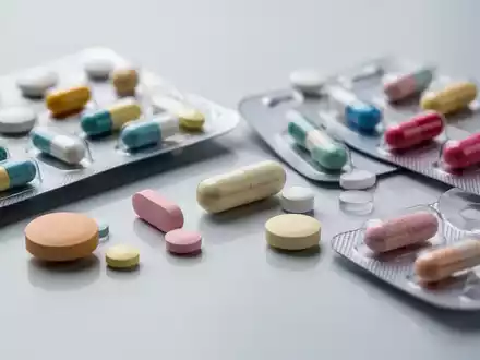 Nahaufnahme verschiedener pharmazeutischer Pillen und Kapseln, einige in Blisterpackungen, andere lose auf einer sterilen Oberfläche. - Foto: über boerse-global.de
