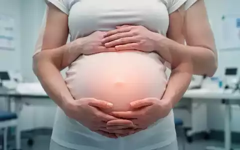 Nahaufnahme der Hände einer schwangeren Frau, die sanft ihren Babybauch streicheln, in einer beruhigenden, medizinischen Umgebung. - Foto: über boerse-global.de