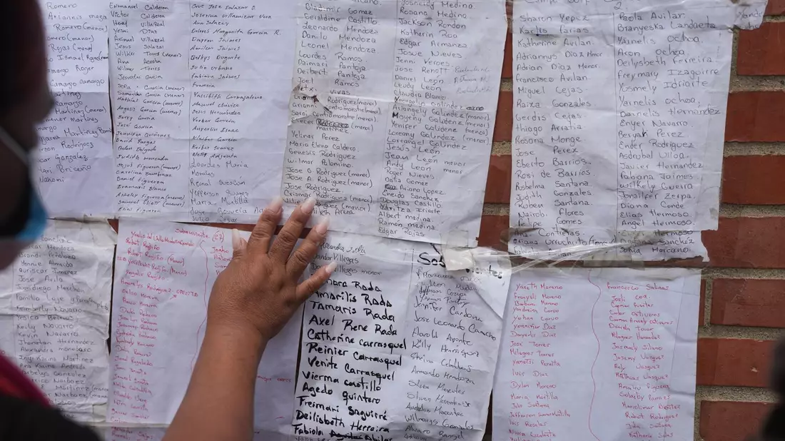 Menschen suchen nach den Namen von Angehörigen auf Listen überlebender Personen. - Bild: Matias Delacroix/AP/dpa