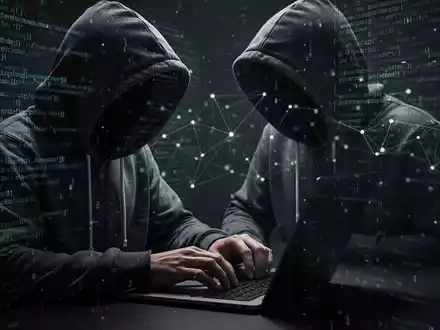Eine Person im Hoodie tippt auf einem Laptop, mit digitalem Code im Hintergrund, der Cybersicherheit und Hacking symbolisiert. - Foto: über boerse-global.de