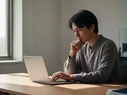 Eine Person sitzt konzentriert an einem Laptop in einem ruhigen, minimalistischen Büro. Die Szene strahlt Gelassenheit und fokussierte Arbeit aus. - Foto: über boerse-global.de