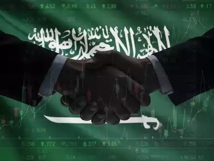 Eine stilisierte Handschlag-Silhouette vor der Flagge Saudi-Arabiens und einem Börsenticker-Overlay, das eine Geschäftspartnerschaft symbolisiert. - Foto: über boerse-global.de