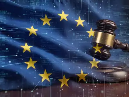 Stilisierte, verschwommene EU-Flagge mit digitalen Datenströmen, die legislative Komplexität und Verzögerung andeuten. - Foto: über boerse-global.de
