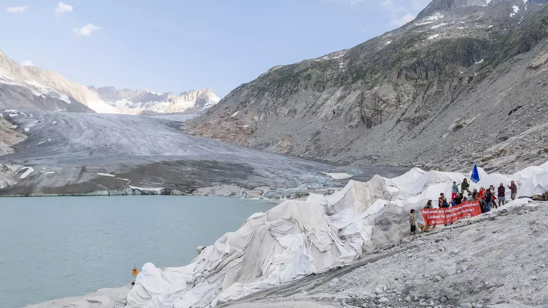 Vertreter von Umweltorganisationen nehmen an einer Aktion teil, bei der der Walliser Regierung symbolisch die Petition „Befreit und schützt den Rhonegletscher! überreicht wird. - Bild: Cyril Zingaro/KEYSTONE/dpa
