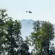 Ein Hubschrauber mit Löschwasser aus dem Chiemsee flog zu dem Brand. - Bild: Uwe Lein/dpa