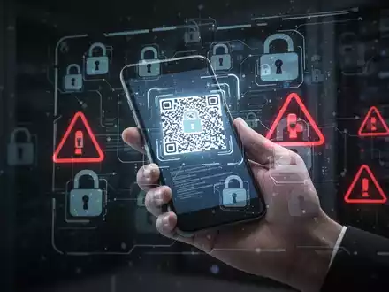 Eine Hand hält ein Smartphone, das einen QR-Code scannt, mit digitalen Schloss- und Warnhinweisen als Symbol für Cybersicherheitsrisiken. - Foto: über boerse-global.de