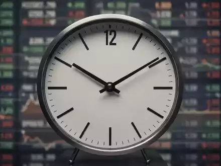 Eine Nahaufnahme einer eleganten Analoguhr, deren Zeiger auf 12:00 stehen, mit einem unscharfen Börsenticker im Hintergrund. - Foto: über boerse-global.de