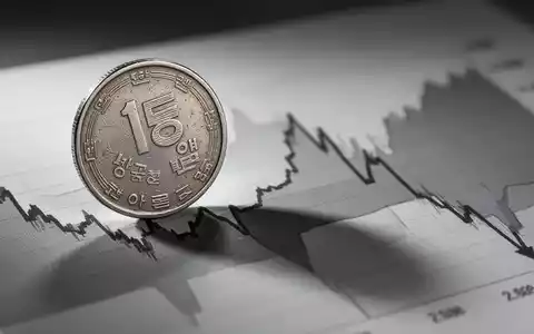 Eine koreanische Won-Münze auf einem Finanzdiagramm, das einen starken Kursrückgang zeigt, symbolisiert den Ausverkauf der Kmw-Aktie. - Foto: über boerse-global.de