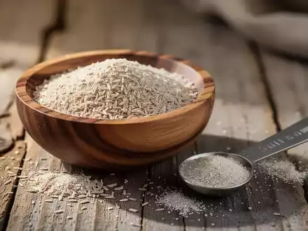 Nahaufnahme von Flohsamenschalen in einer Holzschale mit einem Messlöffel auf einer natürlichen Oberfläche. - Foto: über boerse-global.de