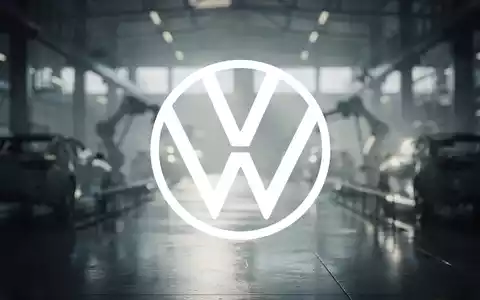 Eine weitlĂ€ufige, schwach beleuchtete Industriehalle mit verschwommenen Maschinen, die Unsicherheit und Herausforderung in der Automobilindustrie darstellt. - Foto: ĂŒber boerse-global.de