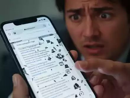 Nahaufnahme eines Smartphone-Bildschirms mit einer fehlerhaften Webseite und einer frustrierten Person im Hintergrund. - Foto: über boerse-global.de