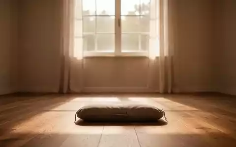 Ein ruhiger Meditationsraum mit einem einzelnen Meditationskissen auf einem Holzboden, beleuchtet von sanftem, warmem Licht. - Foto: über boerse-global.de