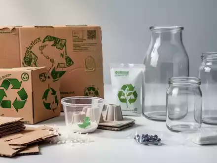 Nahaufnahme verschiedener nachhaltiger Verpackungsmaterialien wie recycelter Karton und Biokunststoffe, die EU-Vorschriften symbolisieren. - Foto: über boerse-global.de