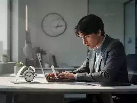 Eine Person arbeitet konzentriert an einem aufgeräumten Schreibtisch in einem ruhigen Büro, mit Fokus auf Zeitmanagement und Produktivität. - Foto: über boerse-global.de