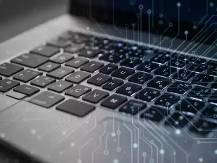 Nahaufnahme einer Laptop-Tastatur mit abstrakten Lichtmustern, die die Linux-Treiberentwicklung für Apple MacBooks symbolisiert. - Foto: über boerse-global.de