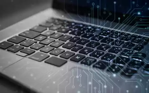 Nahaufnahme einer Laptop-Tastatur mit abstrakten Lichtmustern, die die Linux-Treiberentwicklung für Apple MacBooks symbolisiert. - Foto: über boerse-global.de