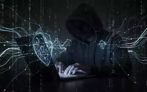 Person in Kapuzenjacke tippt auf Laptop, umgeben von digitalem Code, symbolisiert KI-gestützte Hacking-Bedrohungen. - Foto: über boerse-global.de