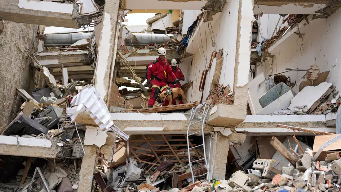 Rettungskräfte aus Spanien durchsuchen die Trümmer eines Gebäudes. - Bild: Fernando Vergara/AP/dpa